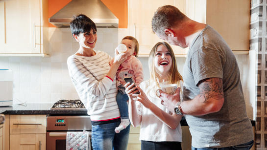 Family Laughing In Kitchen
