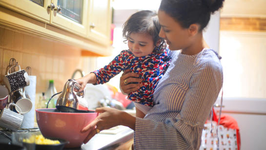 Mother And Young Daughter Cooking Together