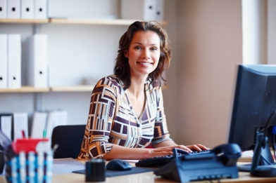 Woman typing on a keyboard in an office