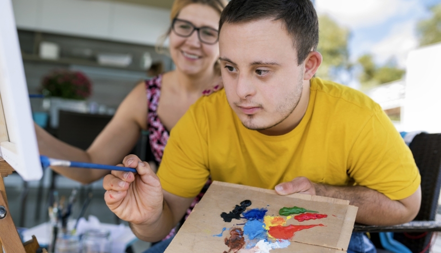 Young Man Painting With Carer Young Man Painting With Carer
