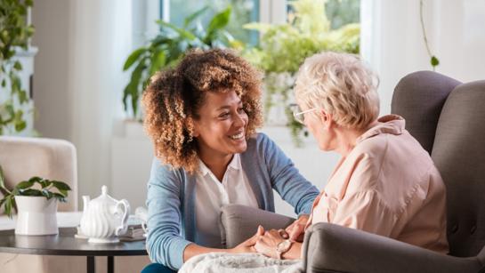 Elderly Woman Speaking With Care Worker