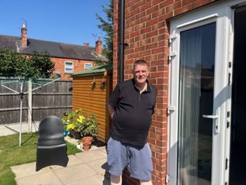 Phil standing on the patio near his home.